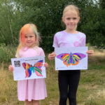 Photo of two young artists holding up their finished butterflies!