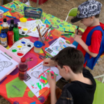 Photo of two children colouring in butterflies at the art & crafts table.