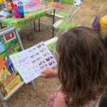 Photo of a little girl holding a butterfly chart.