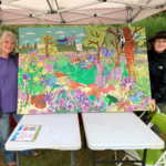 Phot of two people holding up a finished painting. It looks bright and beautiful. It shows lots of different wildlife of the heath, includes reptiles, a frog, butterflies and dragonflies, Woodlark, Nightjar and Dartford Warbler.