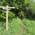 Photo of a finger post at a cross roads of two public footpaths that cross the meadows.
