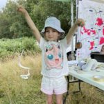 Cute photo of a yound girl holding up a paper snake.