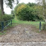 Photo of wide entrance with metal barway fixed in the open position. Ground looks a bit muddy, but there is a hard standing.