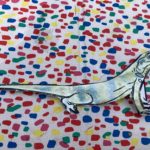 A cut-out of a lizard painting against a bright backdrop.