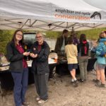 A group of people standing in front of a gazebo displaying amphibian and reptile conservation.
